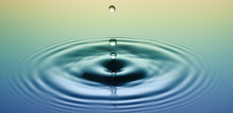 Photo of a pool of water with water drops falling into it