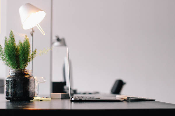 Copywriter's desk with laptop, desk lamp and plant