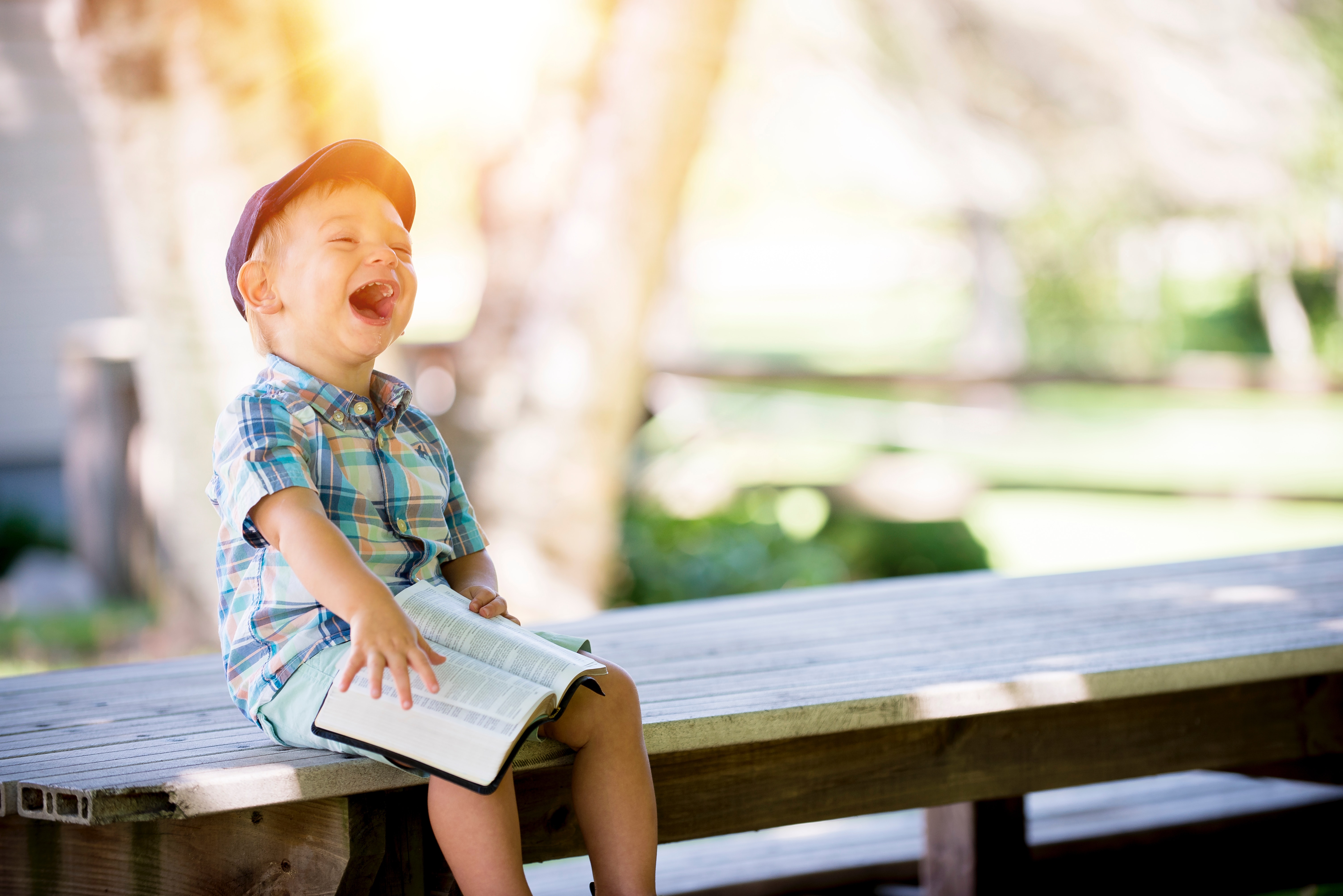 Boy sitting on a bench enjoying reading a good book